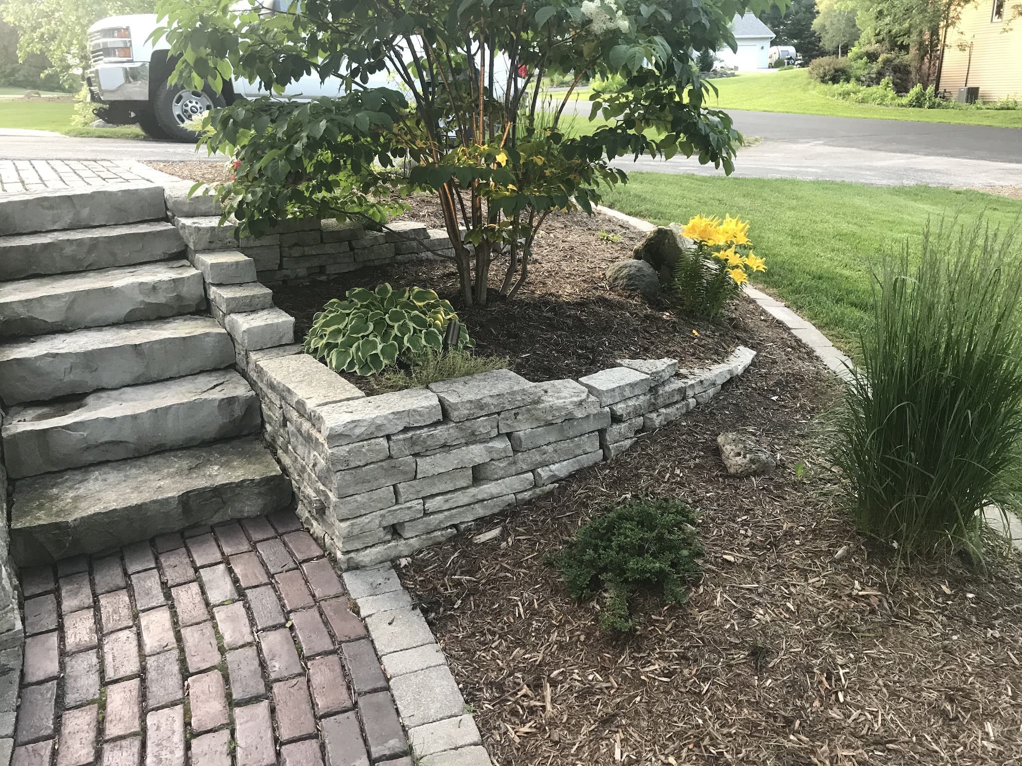 Landscaped garden with stone steps and brick pathway